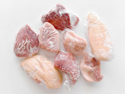 Frozen meat in cling film or plastic wrap.