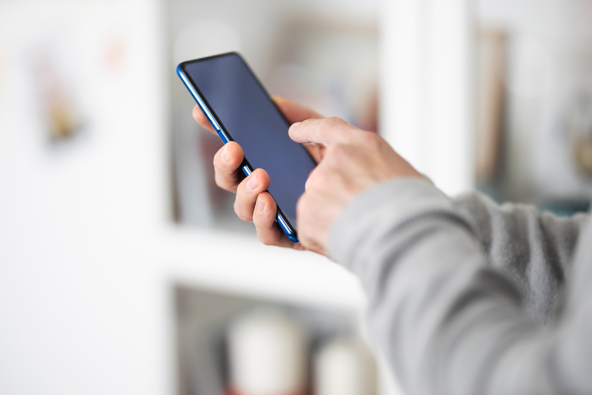Male hands typing on smartphone