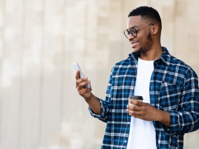 Portrait of african american guy texting sms on smart phone