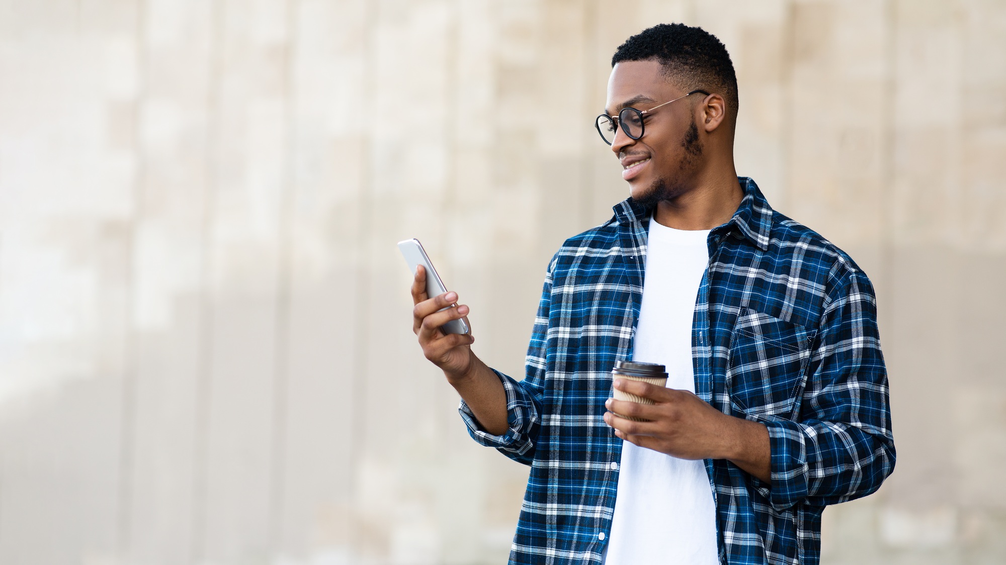 Portrait of african american guy texting sms on smart phone