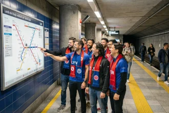 Groupe de supporters lyonnais consultant le plan du métro sur le quai avant de rejoindre le stade